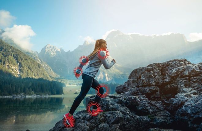 Woman climbing rocks with highlighted joints in a mountainous landscape