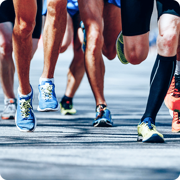 Runners' legs in motion during a race on a paved road