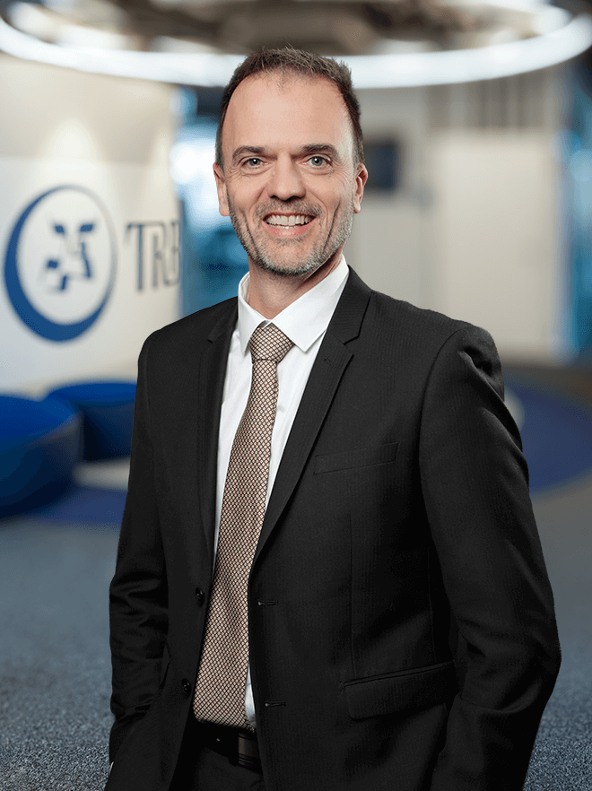 Benoit Dalery, smiling in a suit, standing in an office setting