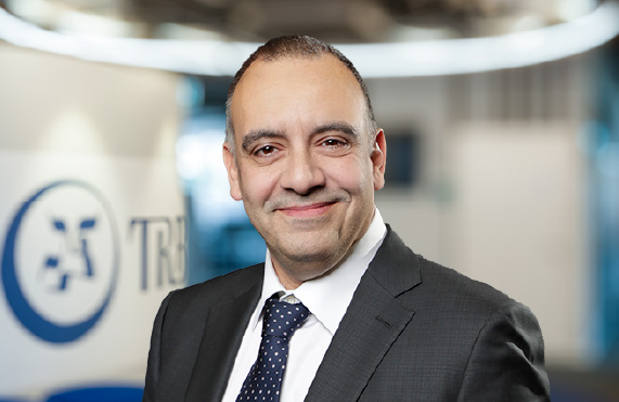 Alessando Di Napoli, smiling in a suit, with a corporate background