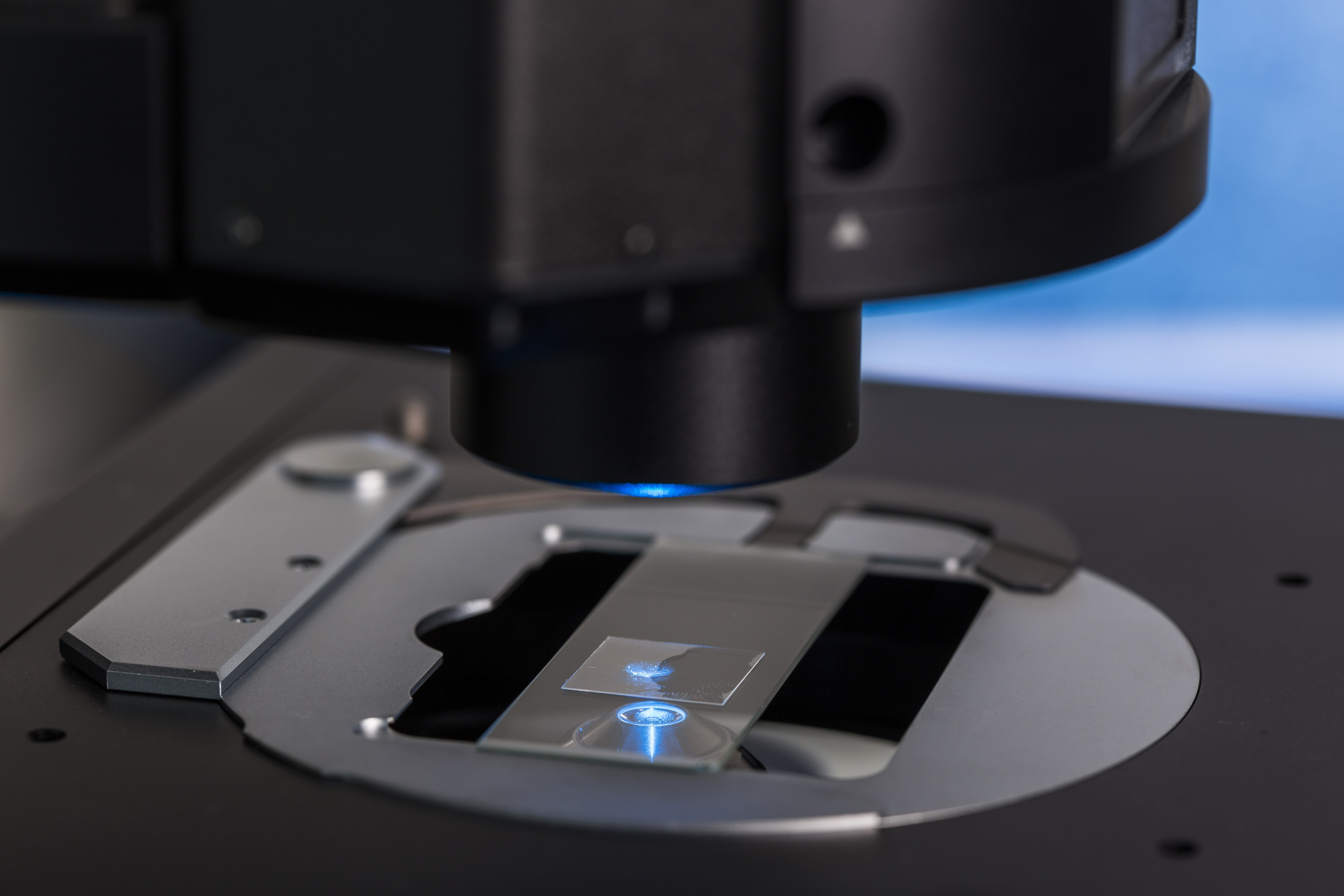 Close-up of a microscope focusing on a glass slide