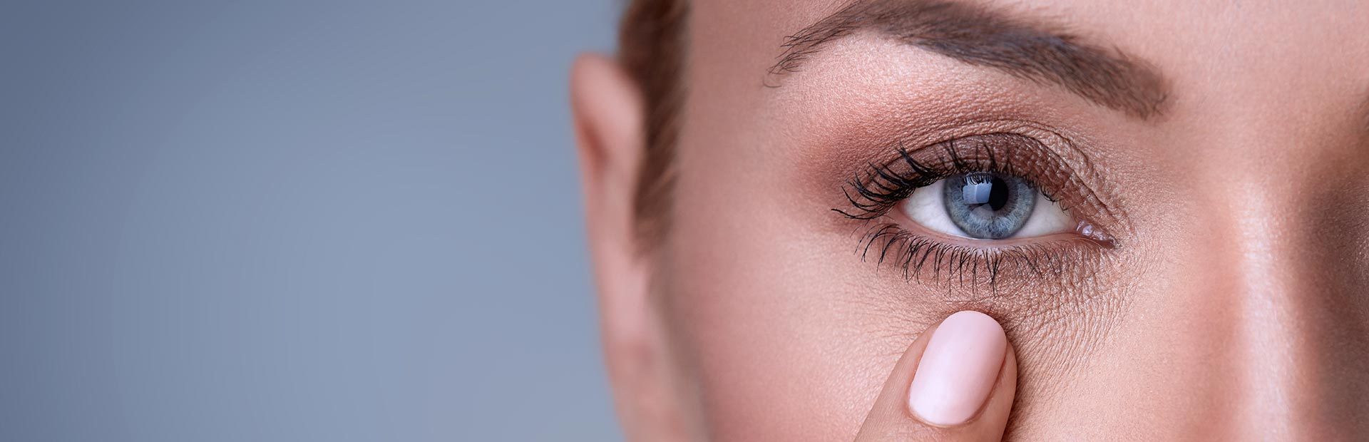 Close-up of a woman touching her eye with a finger