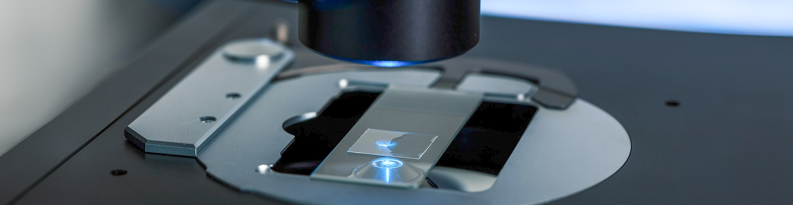 Close-up of a microscope focusing on a glass slide