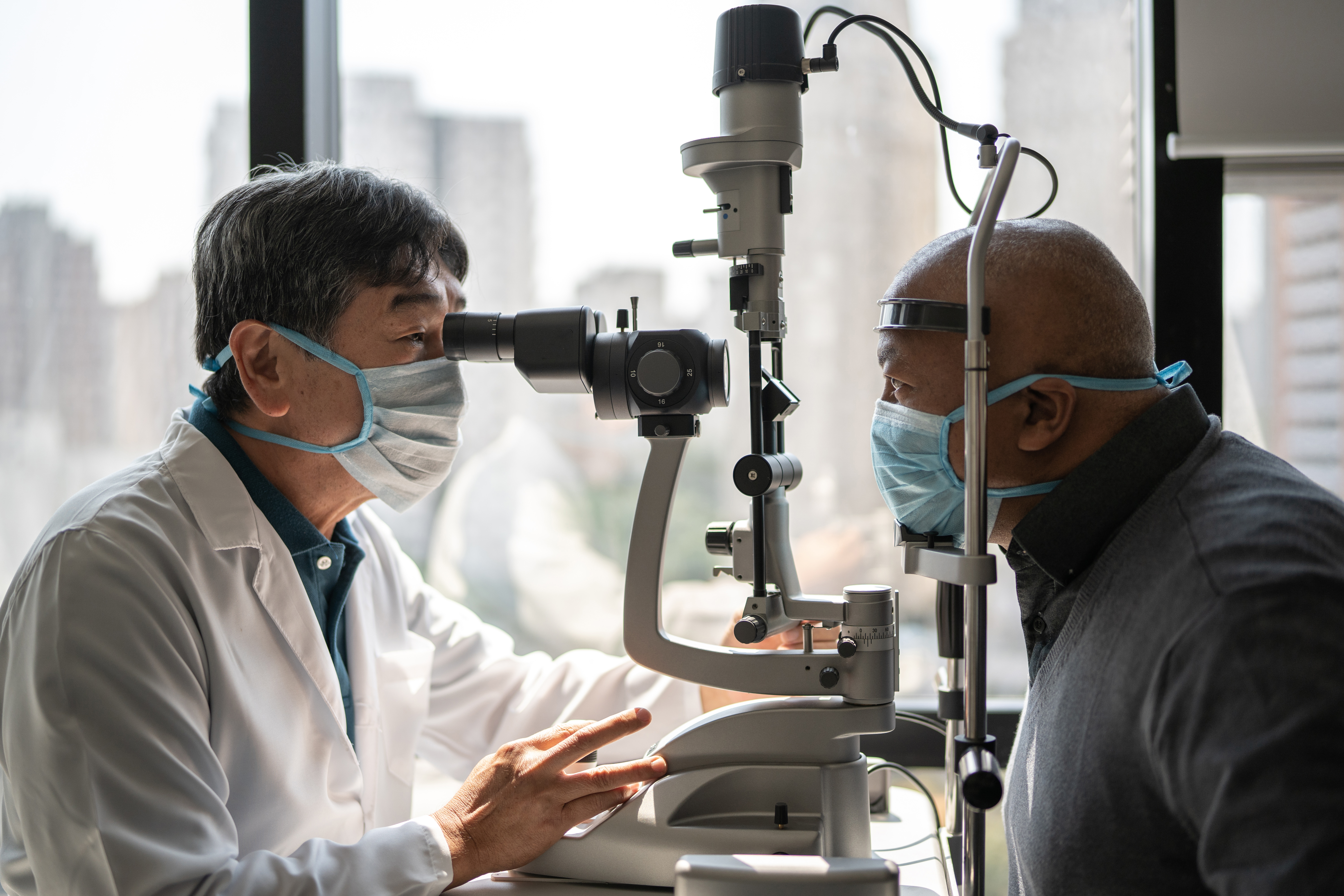Optometrist examining a patient's eyes with a slit lamp
