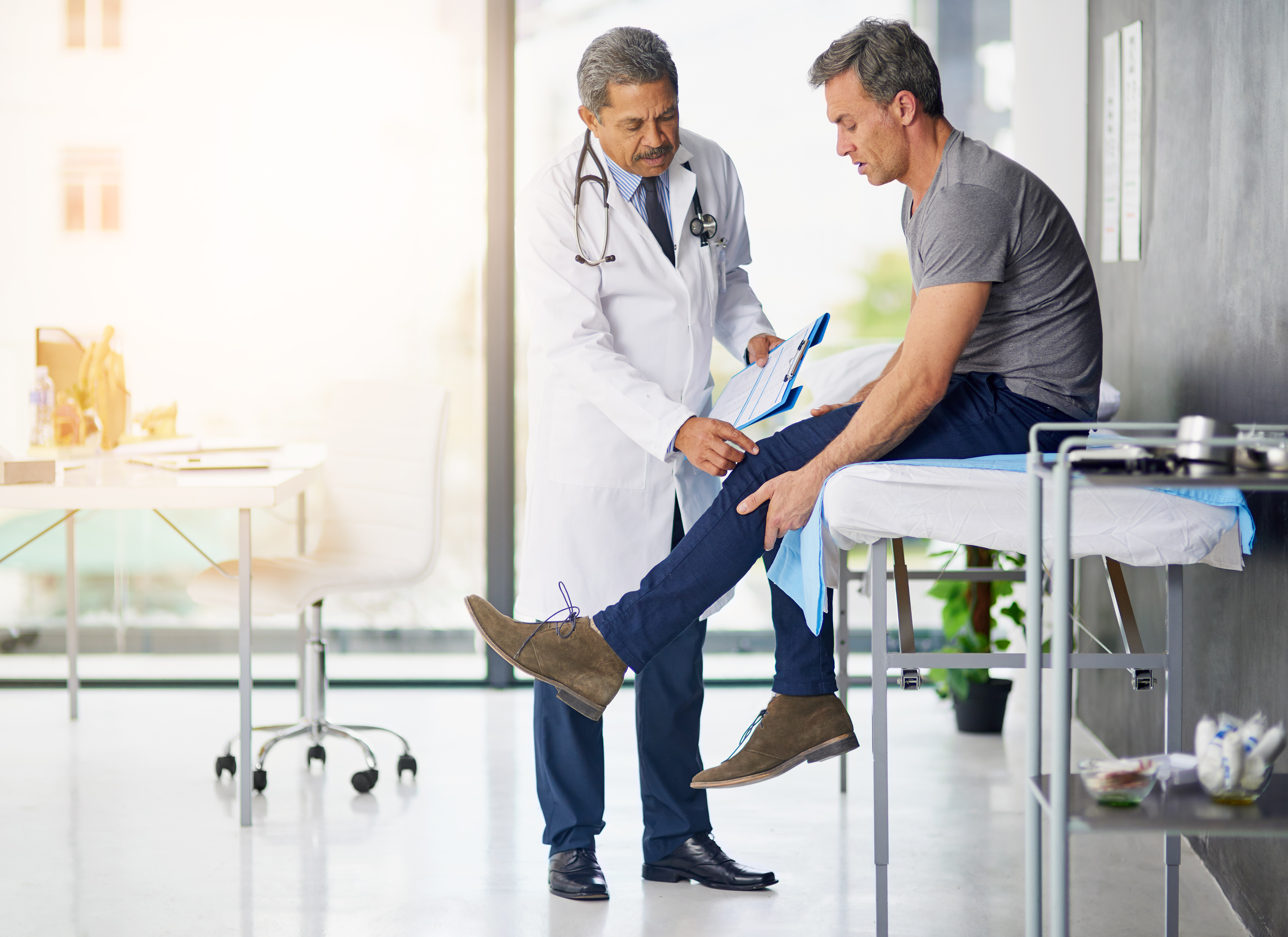 Doctor examining a patient's knee in a medical office