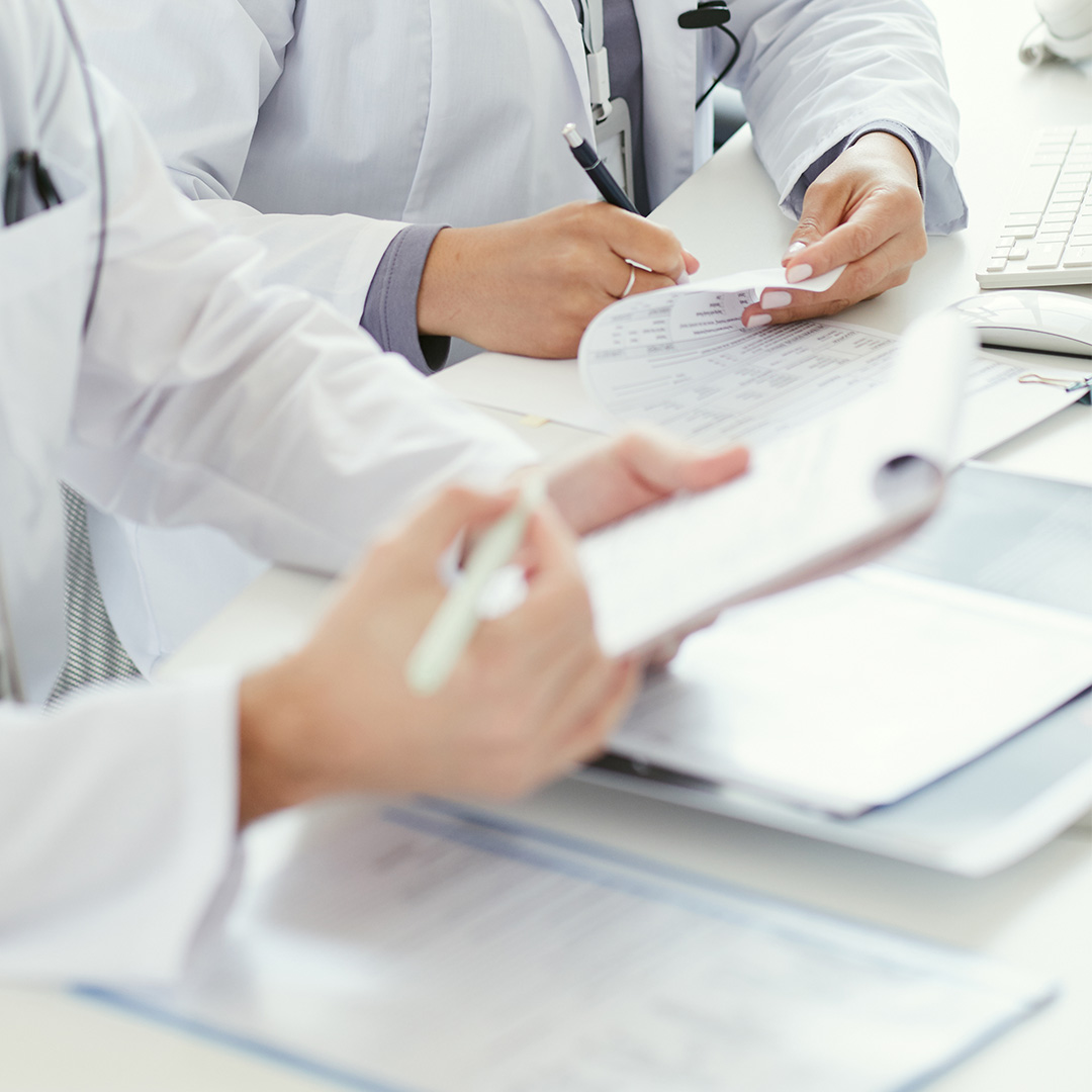 Two doctors reviewing paperwork at a desk